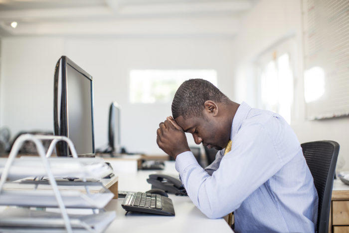 Office man with head in his hands at the desk