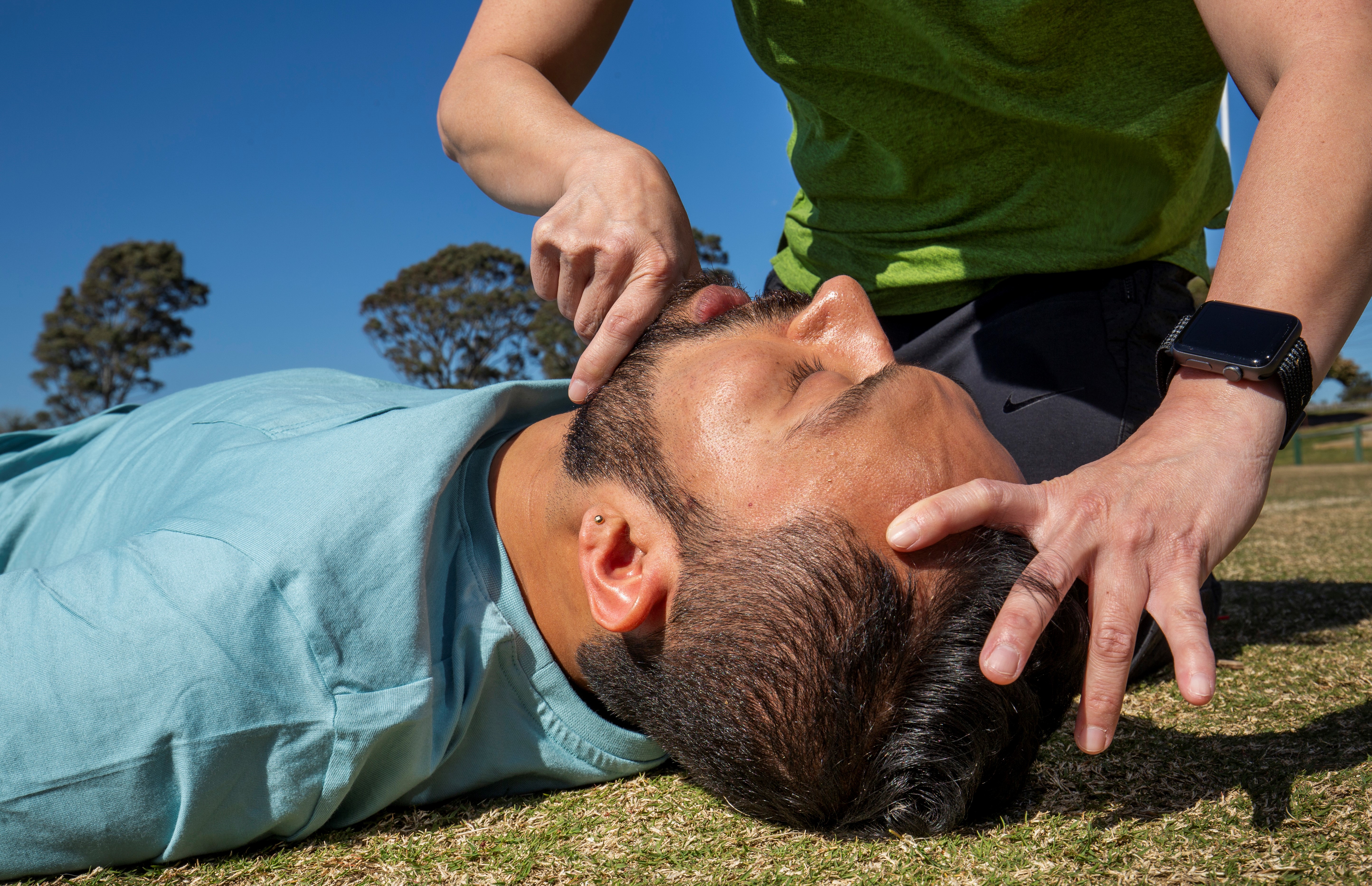 Checking for breathing and objects in mouth of unconscious man