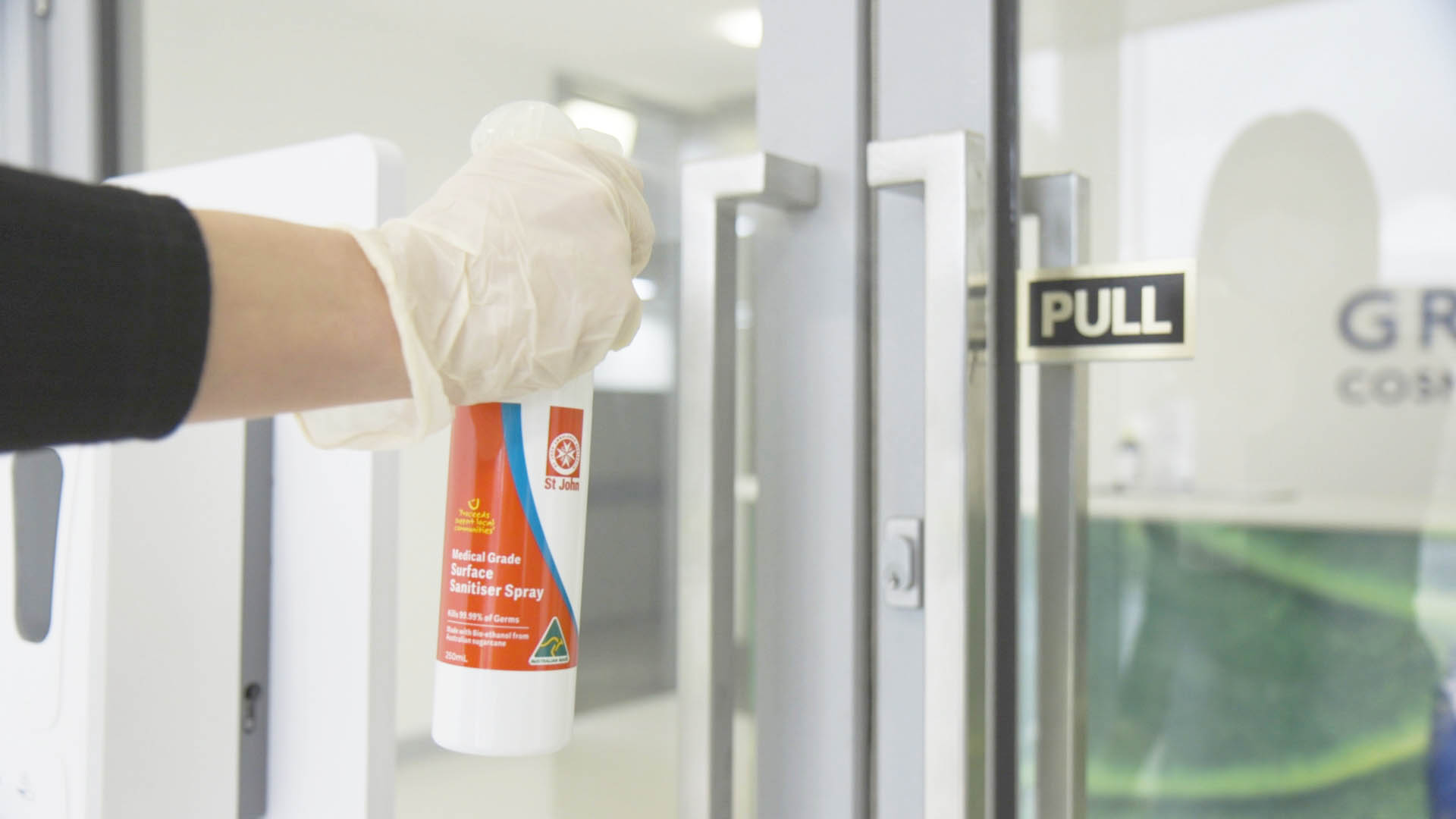 Hand spraying door with St John multi purpose Medical Grade Sanitiser Spray