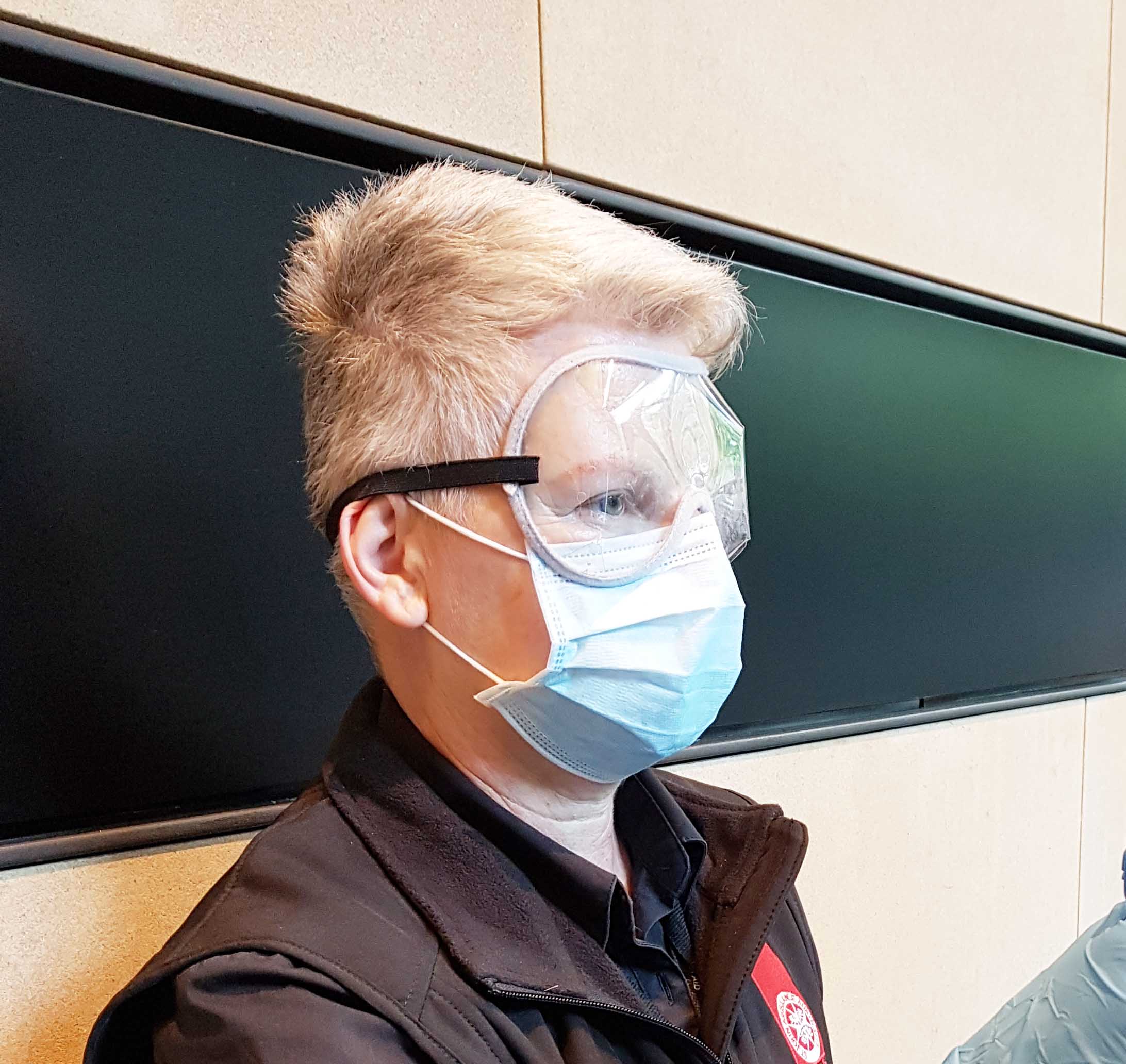 St John woman wearing PPE googles and surgical mask