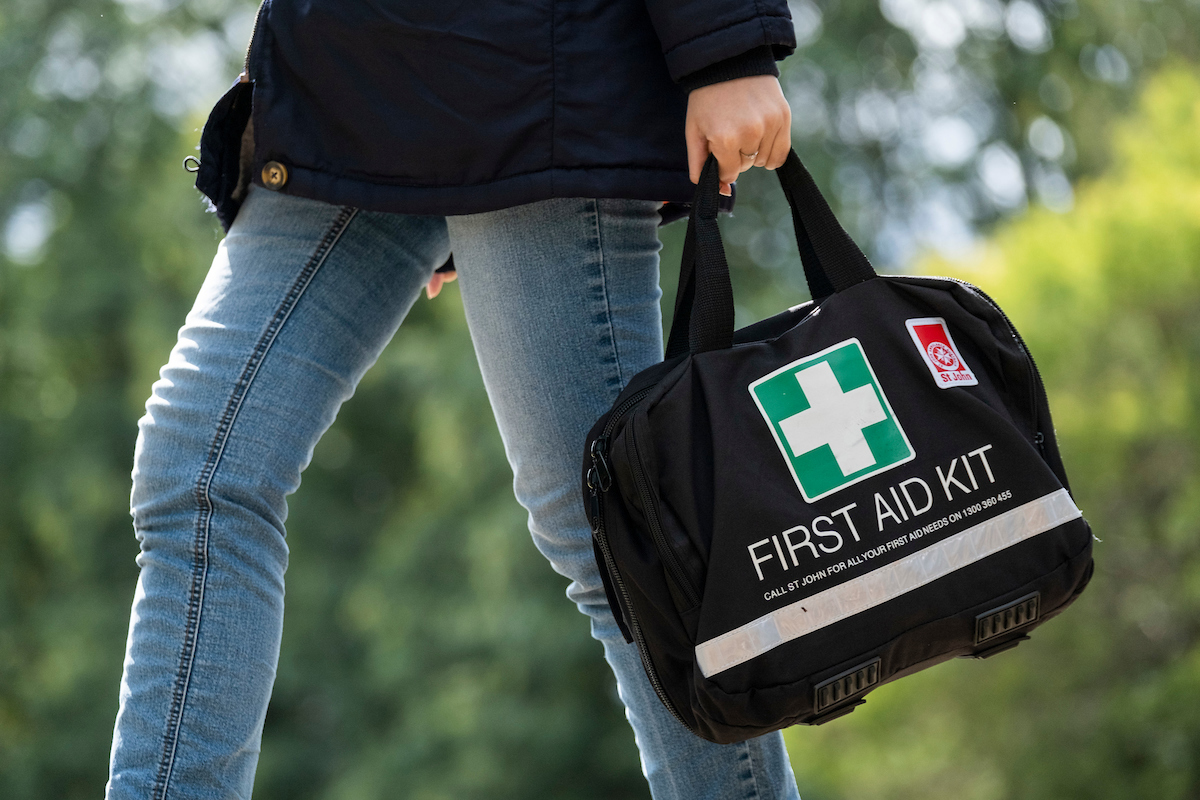 person carrying St John First Aid Kit